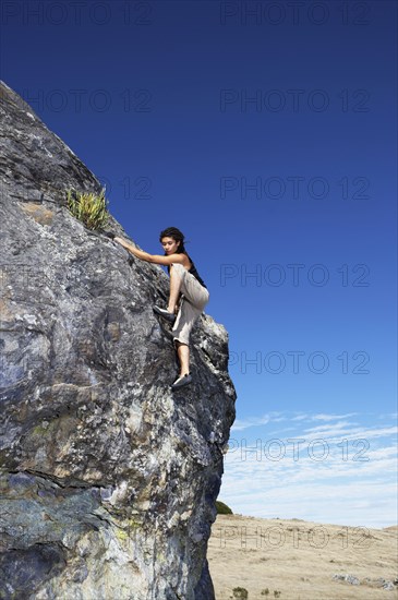 Hispanic climber scaling steep rock face