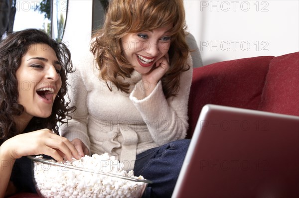 Women watching movie on laptop together