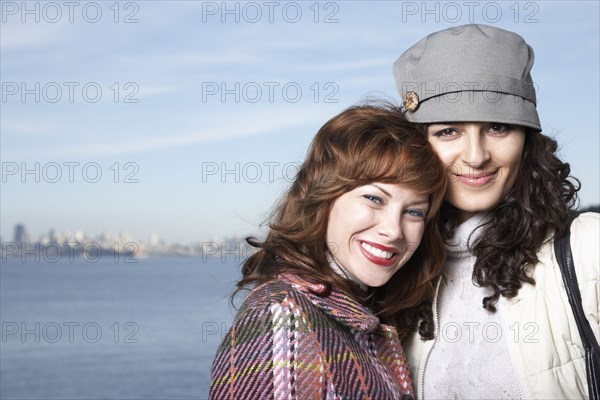 Women hugging by waterfront