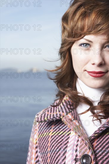 Mixed race woman smiling by waterfront