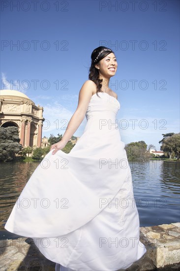 Chinese bride smiling in urban park