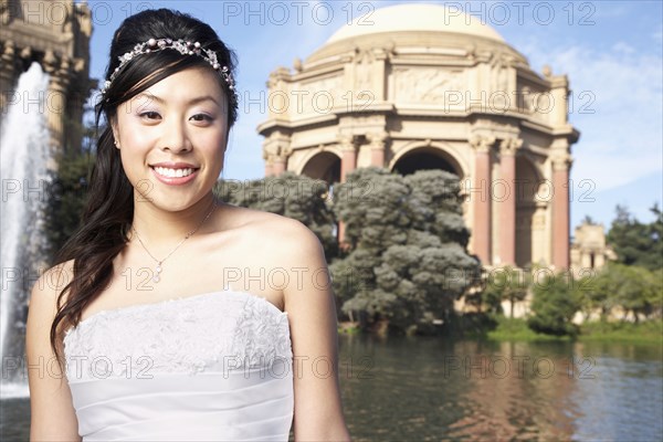 Chinese bride smiling in urban park