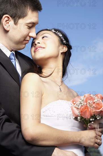 Newlywed couple posing outdoors