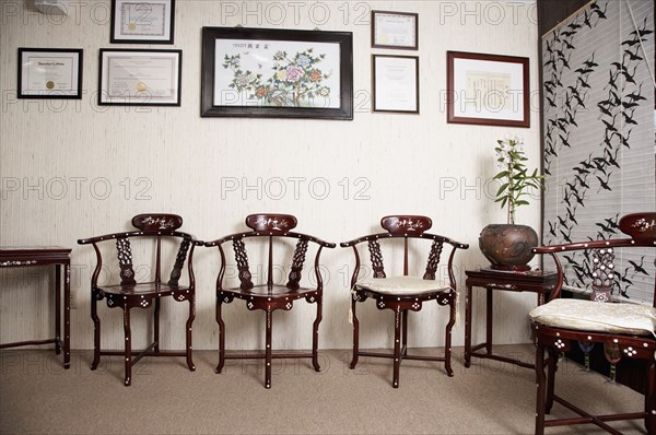 Ornate wooden chairs and picture frames in living room