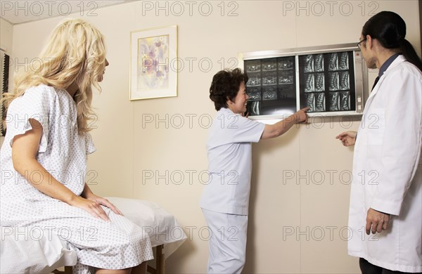 Doctor and nurse examining patient's x-rays in office