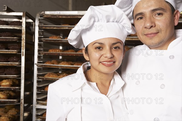 Hispanic bakers smiling in bakery