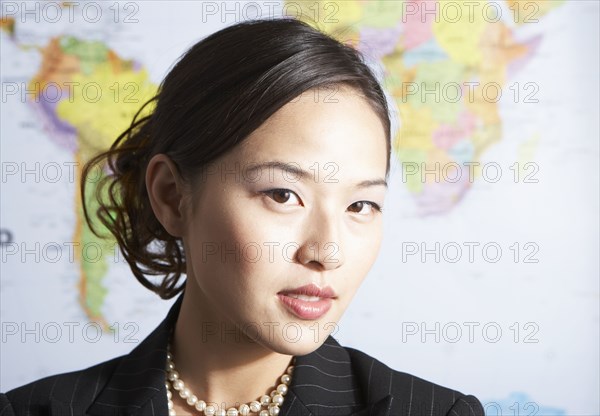 Chinese businesswoman standing by world map