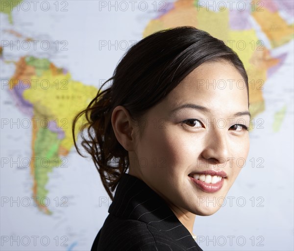 Chinese businesswoman standing by world map