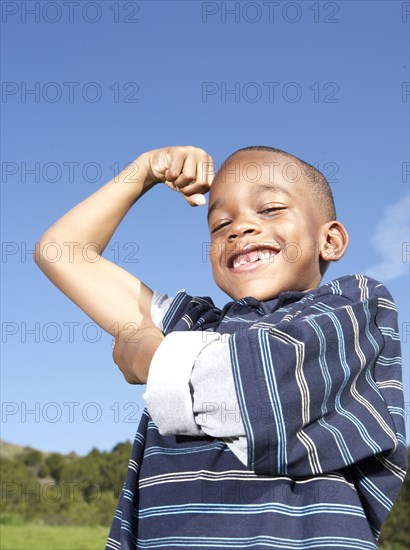 African American boy flexing his muscles