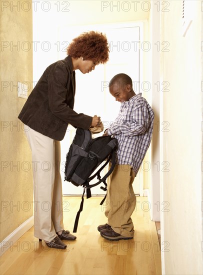 African American mother getting son ready for school