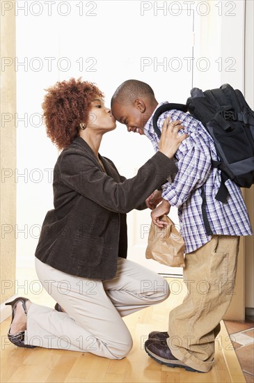 African American mother getting son ready for school