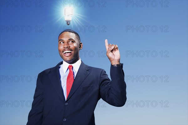 Mixed race businessman with light bulb over his head