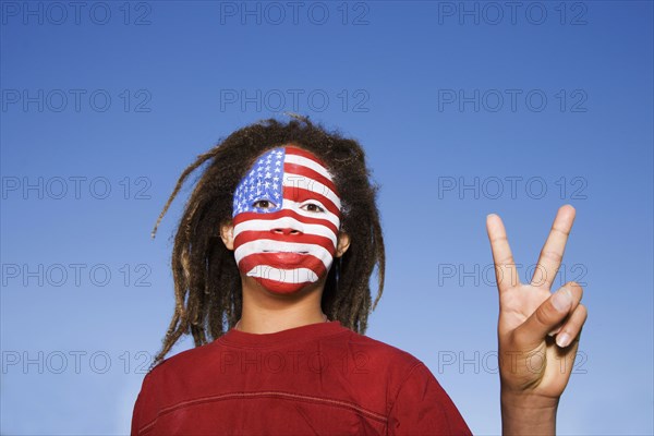 Mixed race boy with American flag painted on face