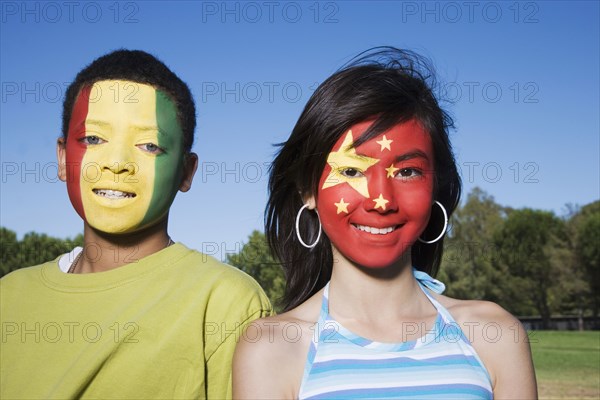 Children with Guinean and Chinese flags painted on faces