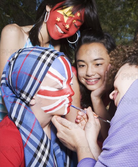 Woman painting Chinese and United Kingdom flags on children's faces