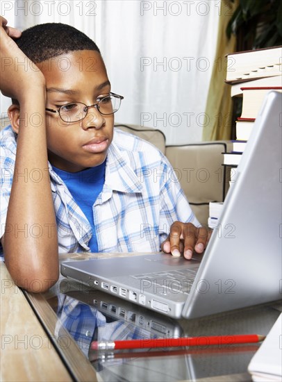 Mixed race boy using laptop