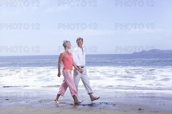 Senior Caucasian couple walking on beach