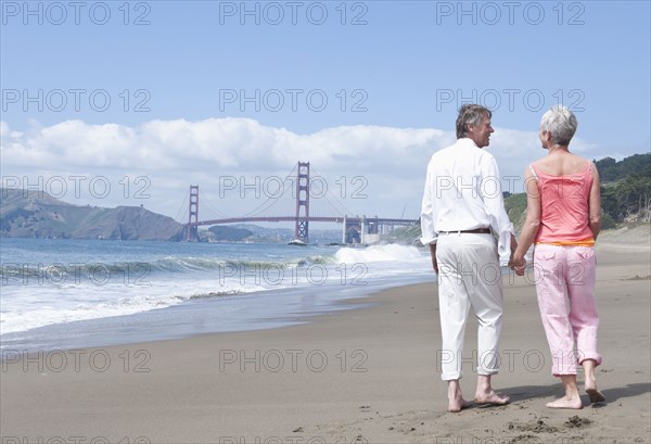 Senior Caucasian couple walking by Golden Gate Bridge