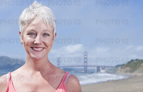 Senior Caucasian woman standing in front of Golden Gate Bridge