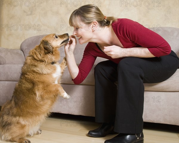 Caucasian woman feeding dog treat