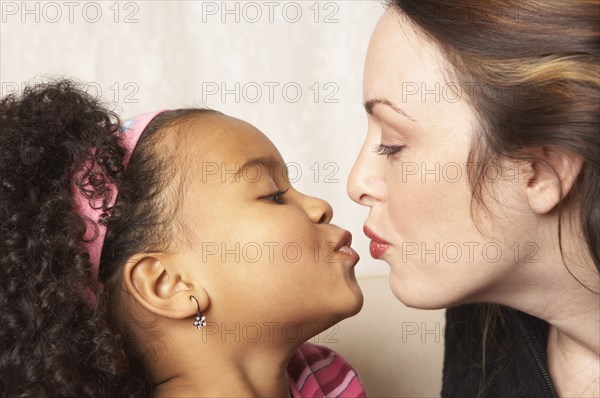 Mother and daughter kissing