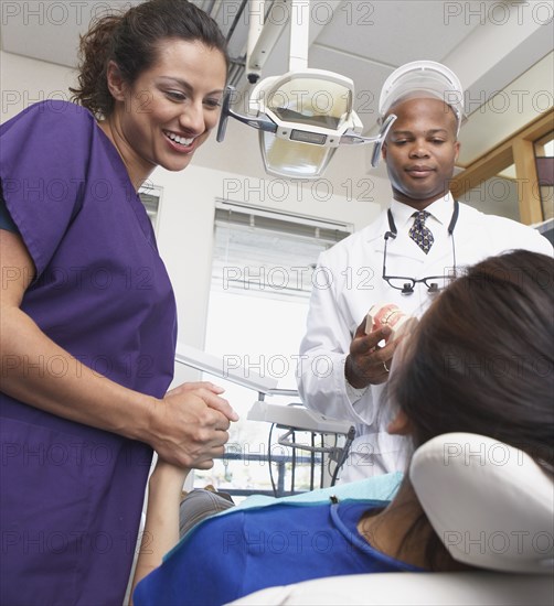 Dentist and nurse talking to patient