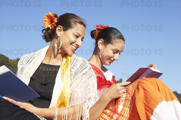 Hispanic women reading in traditional clothing