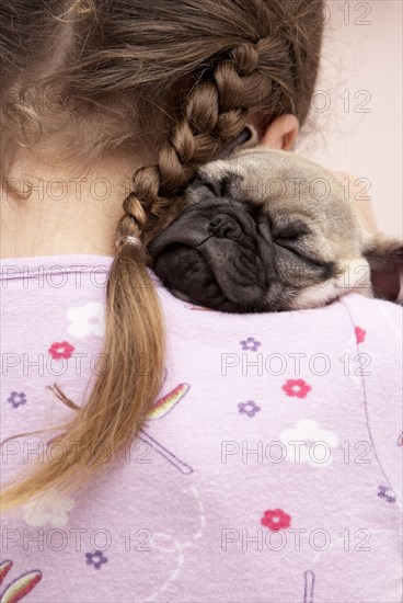 Mixed race girl hugging pug