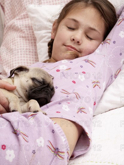 Mixed race girl sleeping with pug