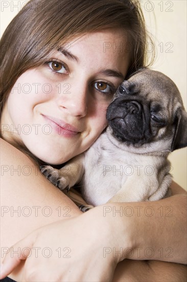 Mixed race woman hugging pug