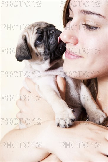 Mixed race woman hugging pug