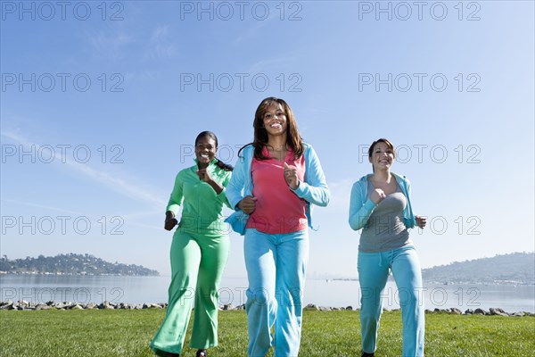 Women jogging by rural lake