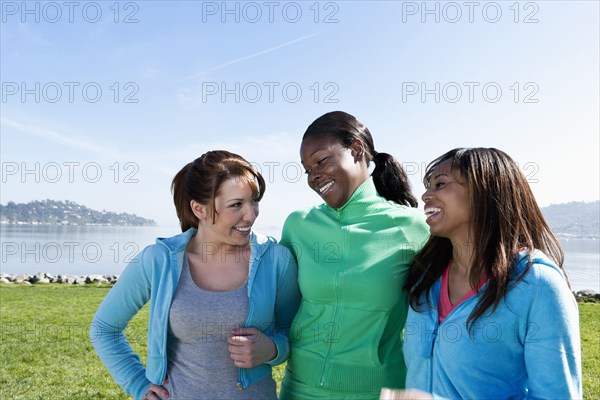 Women smiling by rural lake