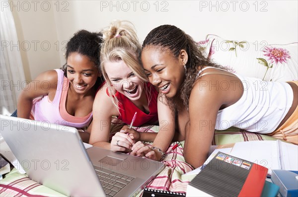 Teenage girls using laptop together