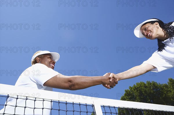 Tennis players shaking hands at net
