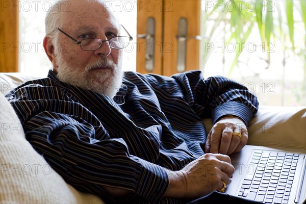 Caucasian man using laptop on sofa