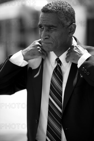 Mixed race businessman adjusting jacket