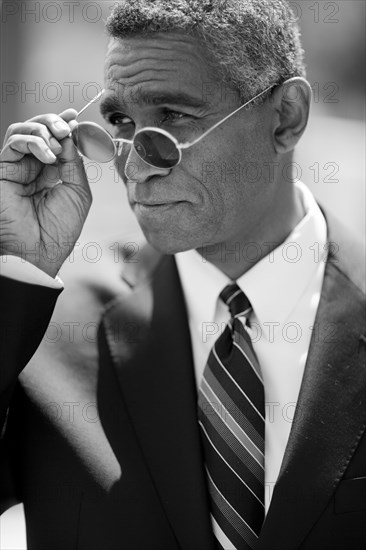 Mixed race businessman adjusting sunglasses