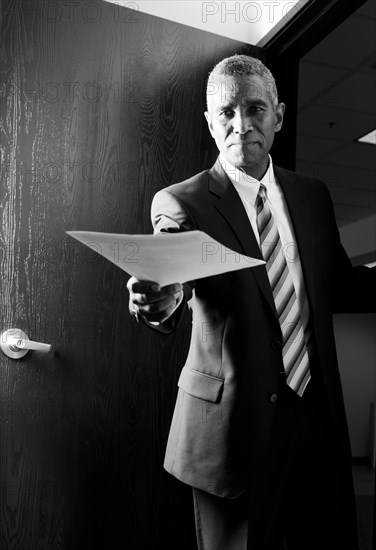 African American businessman holding out paperwork