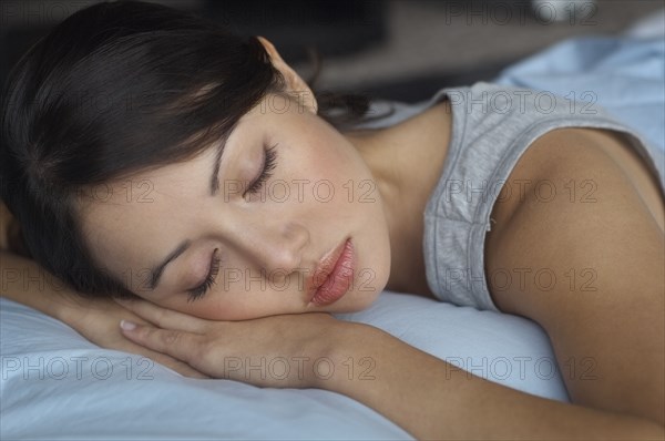 Close up of Hispanic woman sleeping in bed