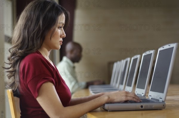 Hispanic woman using laptop at computer lab