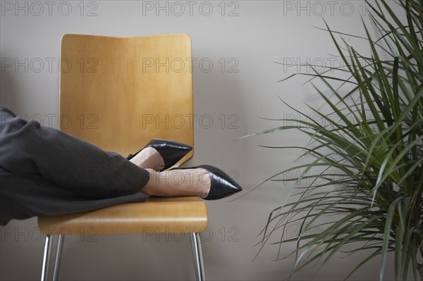 Close up of businesswoman's feet on chair