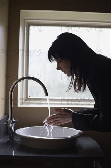 Woman washing hands in sink