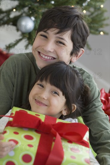 Hispanic brother and sister holding Christmas gift