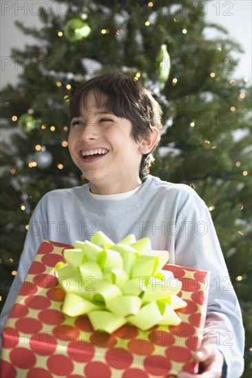 Hispanic boy holding Christmas gift
