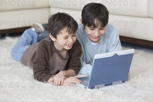 Hispanic brothers looking at laptop