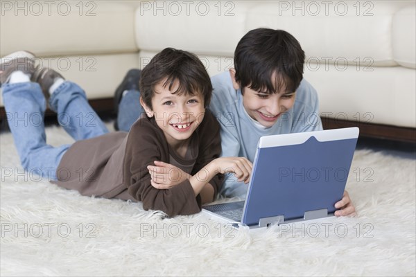 Hispanic brothers looking at laptop