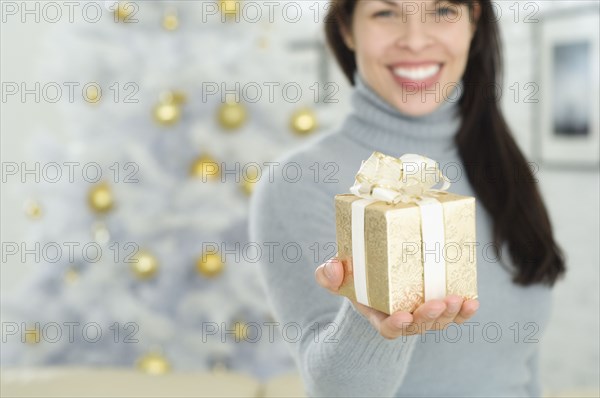 Hispanic woman holding Christmas gift