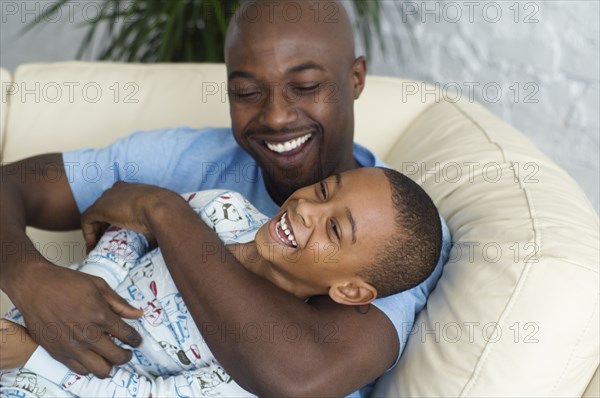 African father tickling son