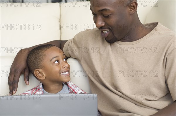 African father and son smiling at each other